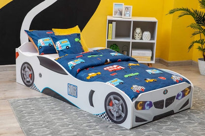 The twin car bed includes a rear spoiler and decals of a front grille, racing tires, and headlights. The white mattresses are designed to resemble the shape of a roadster and even have an attached steering wheel!